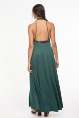 Vestido largo azul marino, de corte fluido, con escote halter, detalles trenzados en los hombros, bolsillos laterales y tajo profundo en la pierna.