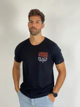Remera negra de manga corta con cuello redondo. Presenta un estampado gráfico en el pecho con líneas abstractas en color naranja, la palabra 'PEACE' en blanco y un texto descriptivo debajo.