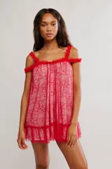 Vestido corto de tul bordado color rojo y rosado, con escote recto, volados sobre los hombros, tiras finas regulables y ruedo terminado en volado. Caída suelta y liviana.