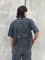 Remera gris con efecto lavado, corte oversize, manga corta y estampado pequeño en el frente.