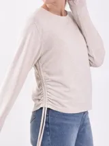 Remera beige claro de manga larga con frunce lateral y corte holgado.