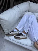Zapatillas bajas de cuero con estampado de manchas en tonos beige y marrón.