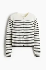Cardigan de punto fino con diseño a rayas horizontales en blanco y negro, cuello redondo y cierre frontal con botones oscuros. Presenta terminaciones acanaladas en el cuello, los puños y el bajo.