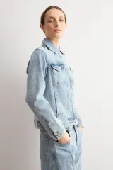 Chaqueta clásica de jean color celeste, con bolsillos frontales con solapa, cierre de botones metálicos y cuello camisero.