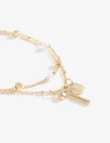 Pulsera plateada de doble cadena con dijes colgantes: una moneda lisa, un cristal y una barra vertical.