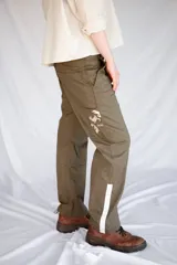 Pantalón de trabajo verde oliva, de tiro medio, confeccionado en gabardina de algodón. Presenta cinta utilitaria trasera, cintura ajustable, bolsillo para metro bordado y cinta reflectiva en los bajos.
