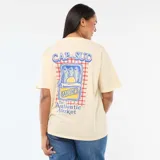 Camiseta de corte oversize color amarillo claro, con cuello redondo y mangas cortas con dobladillo. Presenta un estampado pequeño en el pecho con la frase 'The Authentic Market' y un gráfico de una rodaja de limón.