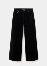 Pantalón de terciopelo negro de tiro medio y diseño wide leg con cinco bolsillos, cierre de botón y cremallera, y trabillas para cinturón.