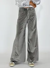 Pantalón de terciopelo gris, de corte palazzo, con bolsillos laterales y cierre frontal con botón y cremallera.