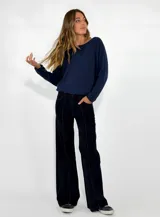Pantalon de denim negro de corte recto y tiro medio, con costuras a la vista en color contrastante y bolsillos laterales.