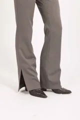Pantalón sastrero de tiro alto y corte recto con caída amplia, confeccionado en tela de sastre color negro.