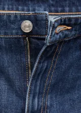 Jeans Annie de tiro bajo y diseño wide leg con perneras anchas, confeccionados en tejido denim de algodón en color azul oscuro. Cuenta con cinco bolsillos, trabillas para cinturón y cierre frontal con botón y cremallera.