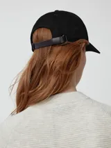 Gorro de béisbol negro, estilo 'dad hat', con la palabra "GOOSE" bordada en el frente en hilo negro tono sobre tono y el logo de New Era bordado en el lateral.