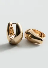 Aros dorados con diseño en forma de gota y volumen, de acabado brillante con cierre a presión.