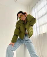 Campera puffer verde oliva con cierre frontal y cuello alto.