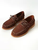 Sandalias de cuero gamuzado color marrón chocolate, diseño tipo huarache con tiras entrelazadas, tira en el empeine, talón cerrado y hebilla metálica de ajuste lateral.
