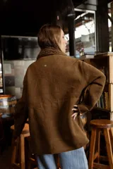 Campera de efecto gamuza color tostado con interior de corderito sintético. Presenta cierre frontal, bolsillos delanteros con solapa, cintura ajustable con cordón y puños con detalle de corderito.