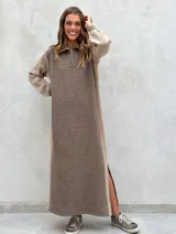 Vestido largo de punto en color verde oliva, con diseño de paneles en dos tonos de verde, mangas largas con textura perforada y tajos laterales en el ruedo.