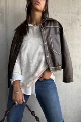 Sweater de punto con diseño floral en tonos crema y natural, de cuello redondo y manga larga.