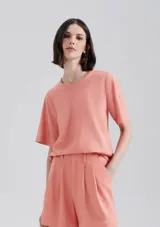 Blusa manga corta de tejido liso, color salmón, con cuello redondo y corte recto.
