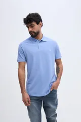 Remera polo verde militar de algodón pima, con cuello y puños acanalados, cierre frontal de tres botones y pequeño bordado de ave en el pecho.