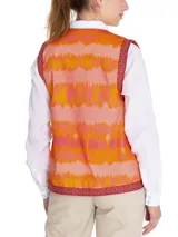 Chaleco sin mangas estilo boho, con estampado de ondas en tonos naranja, rosado y amarillo. Presenta bordes con detalles geométricos en color bordó y cierre frontal abierto.