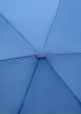 Paraguas mini plegable de color azul, con diseño liso y correa de mano a juego. Incluye detalle de placa metálica con logo de la marca.