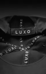 Gorra de béisbol de seis paneles, color gris oscuro o carbón, con visera curva y botón superior.