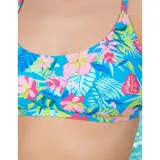 Bikini de dos piezas con estampado tropical de flores y hojas en tonos rosados, azules y verdes sobre fondo celeste. El corpiño es de diseño triangular con espalda cruzada, y la bombacha es cola less con tiras laterales decorativas.