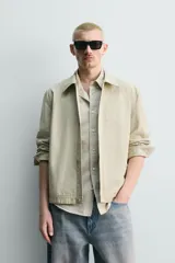 Sobrecamisa de corte regular fit en color beige, confeccionada en popelín de algodón. Cuenta con cuello solapa, manga larga con puño abotonado, bolsillos ocultos en las costuras de la cadera y cierre frontal con botonadura oculta.