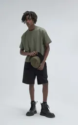 Remera de manga corta y cuello redondo, color verde militar, con calce boxy fit, caracterizada por ser ligeramente más corta y tener mangas amplias.