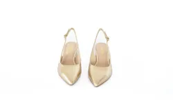 Zapato destalonado de color dorado, con punta fina y taco cuadrado bajo. Cuenta con una tira ajustable en el talón con hebilla metálica.