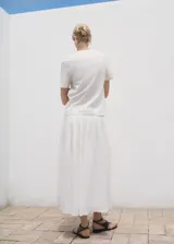 Camiseta blanca de algodón con cuello redondo, manga corta y diseño estampado en color rojo en la parte frontal.