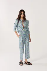 Pantalón de lino metalizado con estampado floral, tiro medio, piernas rectas y bolsillos laterales.