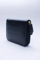 Billetera marrón tipo sobre con cierre de cremallera, confeccionada en cuero con textura tipo cocodrilo y forro textil rojo. Cuenta con múltiples ranuras para tarjetas, documentos y billetes.