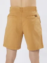 Bermuda de gabardina color caramelo, con cierre de botón y cremallera, bolsillos laterales y trabillas para cinturón.