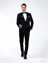 Ambo de fiesta Florenzi modelo Selvino, corte slim fit. Incluye saco con solapa en punta de raso, un botón frontal y botones forrados, junto con pantalón de vestir al tono. Presenta un sutil diseño de fantasía en la tela.