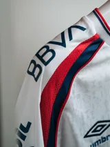Camiseta de arquero Umbro del Club Nacional de Football, temporada 2026. Diseño azul marino con detalles en blanco y rojo en cuello y hombros. Incluye logo de Umbro, escudo del club y sponsors impresos en el frente y mangas.