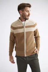 Campera tejida de algodón con diseño color block en tonos beige y marrón. Presenta cierre frontal completo, cuello alto y textura acanalada.