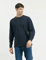 Remera de manga larga color negro, con cuello redondo y puños en punto canalé.