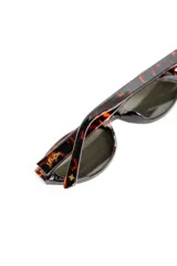 Lentes de sol Lemon de armazón ovalado color negro y cristales oscuros, con detalle de la marca en letras doradas en la patilla.