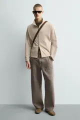 Mocasín de vestir para hombre confeccionado en piel con acabado de serraje en color mostaza. Presenta un diseño de horma redonda con detalle de tachas metálicas en los laterales y suela de goma flexible.