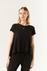 Remera negra de manga corta con cuello redondo y corte amplio, con ruedo asimétrico y más largo en la espalda.
