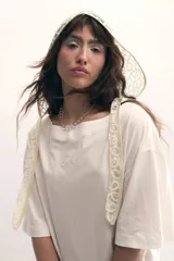 Remerón gris de cuello bote, con bordado del monograma de la marca a tono y encaje blanco integrado en el ruedo. Confeccionado en malla fina compactada de algodón.