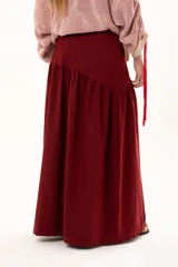 Pollera larga de corte recto con detalle de volado en la parte inferior, confeccionada en tela color bordó.