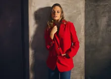 Blazer de pana forrado de color rojo, con solapa de muesca, bolsillos con solapa y botones dorados con relieve. Diseño de corte recto y estructurado.