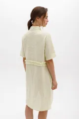 Vestido camisero color ladrillo con cuello, cartera y volados frontales y laterales en lino color lima. De calce relajado y mangas cortas.