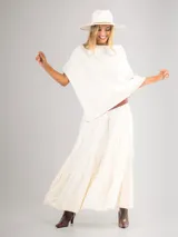 Poncho de corte holgado y diseño minimalista, confeccionado en tejido liviano de color beige, con cuello redondo y caída fluida.