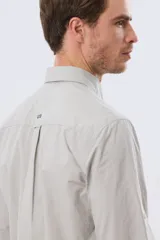 Camisa celeste de manga larga confeccionada en algodón, con cuello camisero, cierre frontal de botones, bolsillo en el pecho y diseño de cuadros sutiles.