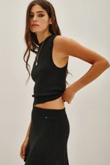 Top sin mangas con cuello halter, confeccionado en tejido de punto con acabado metalizado. Presenta un ajuste al cuerpo y diseño minimalista.